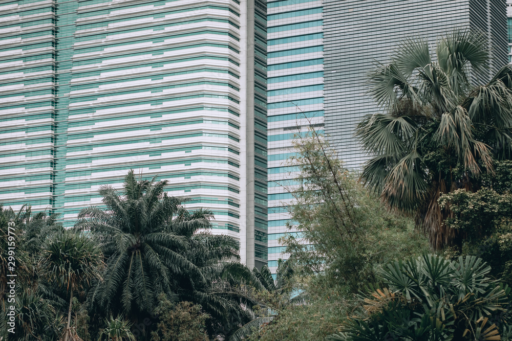 Kuala Lumpur, Malaysia – March 17, 2019. Image of the downtown, modern buildings surrounded by bushy palms, urbanistic; mega polis concept.
