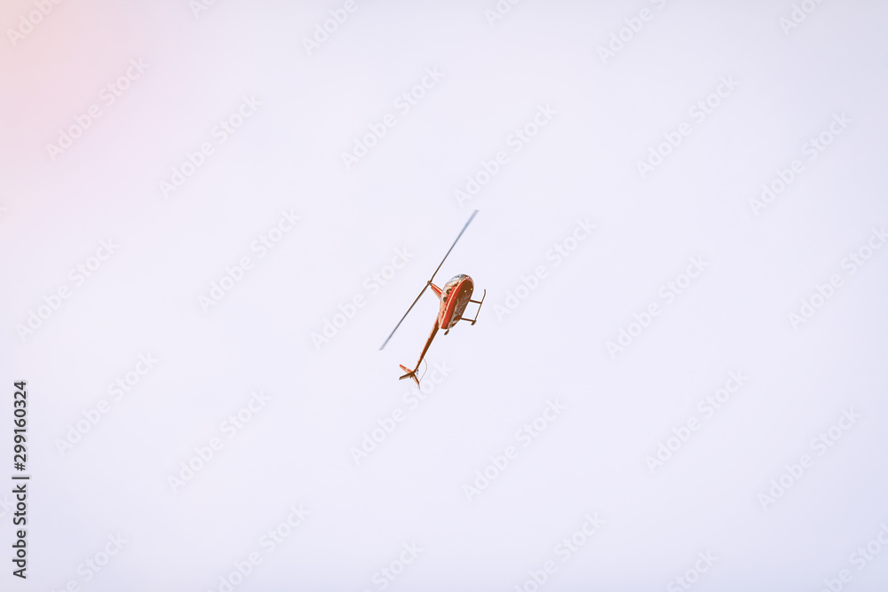 Silhouette of a chopper high in the blue sky seen from below, the military maneuvers; worm’s eye view. Silhouette of a chopper high in the blue sky seen from below, the military maneuvers; worm’s eye view.