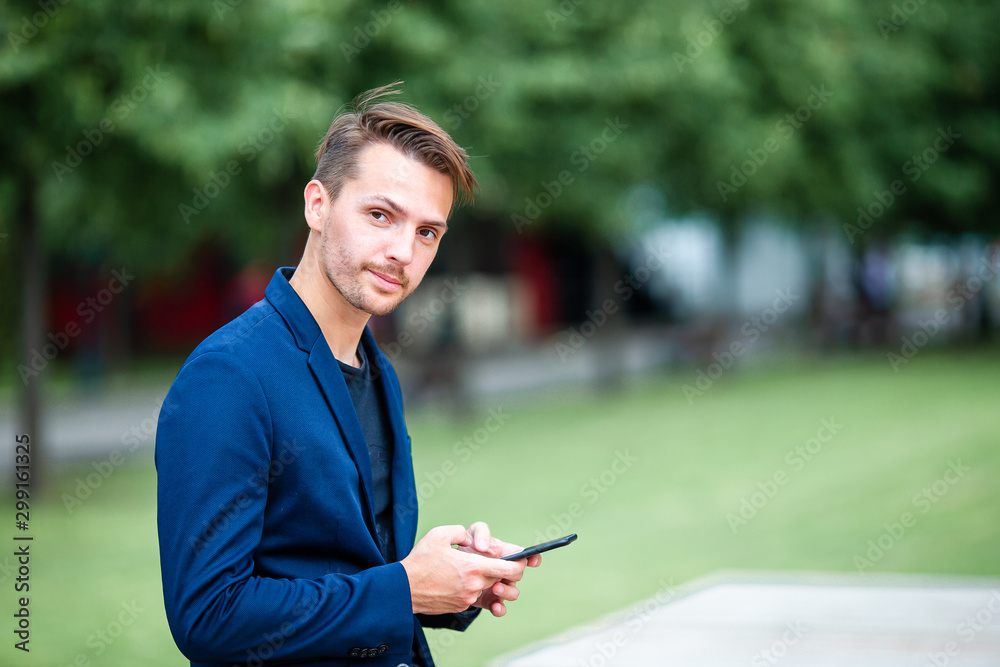 Man is reading text message on mobile phone while walking in the park Man is reading text message on mobile phone while walking in the park