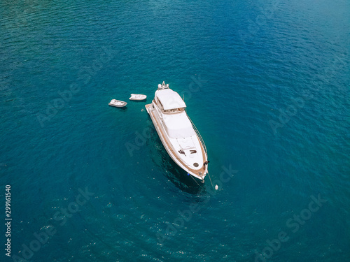 Drone shot of the beautiful white yacht in the warm blue sea  wealth concept. © Semachkovsky 