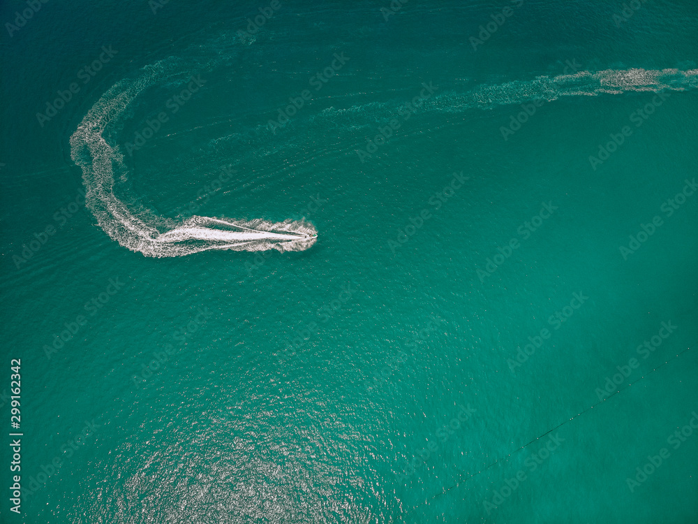 .Top view of the speedboat, leaving trace on the surface of the blue water; vessels concept..