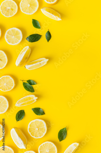 Fruit frame. Lemons and leaves on yellow background top view copy space