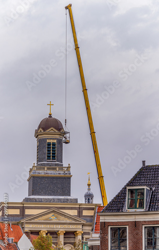 October 14, 2019 Leiden, Netherlands, Big yellow crane during the maintenance  of Hartebrugkerk  church, one of the many  Leiden’s churches photo