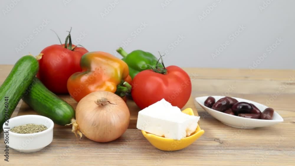 Ingredients for a Greek salad on wooden table. Vegetarian cuisine. Healthy food. Greek salad recipe execution. Fresh vegetables for salad. Olive oil, Olives, Feta cheese, tomatoes. Ingredients for a Greek salad on wooden table. Vegetarian cuisine. Healthy food. Greek salad recipe execution. Fresh vegetables for salad. Olive oil, Olives, Feta cheese, tomatoes.