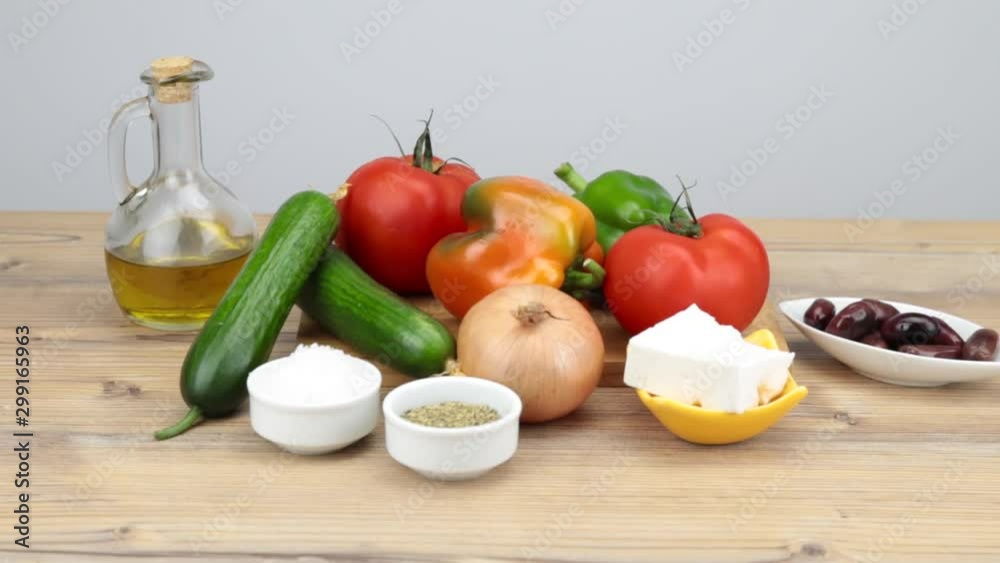 Ingredients for a Greek salad on wooden table. Vegetarian cuisine. Healthy food. Greek salad recipe execution. Fresh vegetables for salad. Olive oil, Olives, Feta cheese, tomatoes. Ingredients for a Greek salad on wooden table. Vegetarian cuisine. Healthy food. Greek salad recipe execution. Fresh vegetables for salad. Olive oil, Olives, Feta cheese, tomatoes.