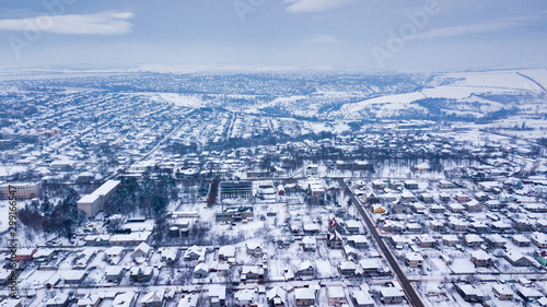 aerial view village among the fields and forests in winter. winter landscape snow covered field and trees in countryside.