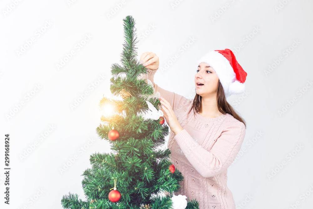 Holidays concept - Girl in santa hat decorated christmas tree. Waiting for christmas. Holidays concept - Girl in santa hat decorated christmas tree. Waiting for christmas.