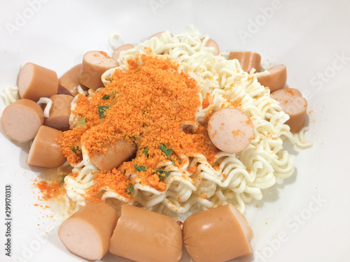 Pieces of noodles and hot dogs in a wooden floor cup