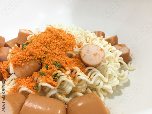 Pieces of noodles and hot dogs in a wooden floor cup