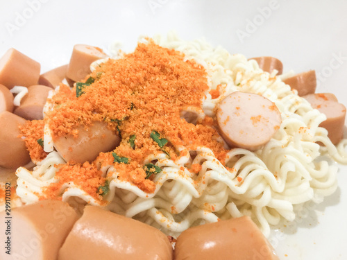 Pieces of noodles and hot dogs in a wooden floor cup