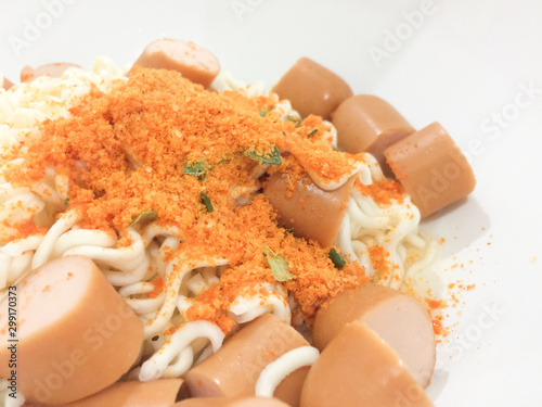 Pieces of noodles and hot dogs in a wooden floor cup