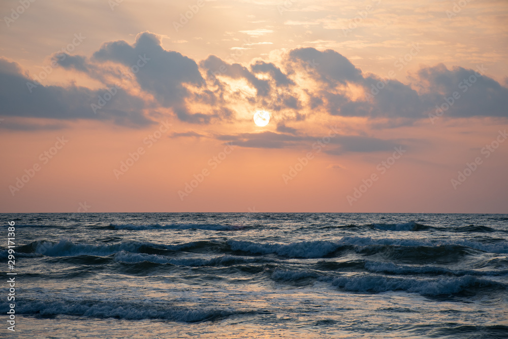 Beautiful sunset on the Baltic Sea with waves and reflections on the water