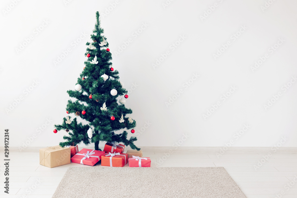 Holidays, celebration and gifts concept - Christmas tree and many present boxes on white indoors with copy space