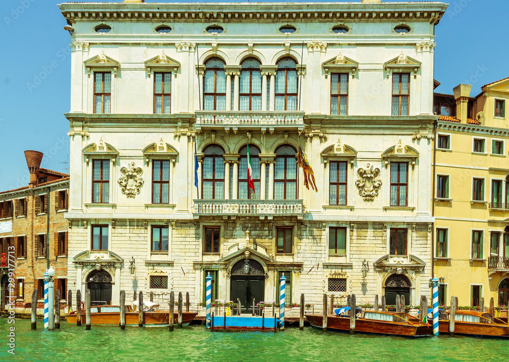 facade of venetian administration building with boats parked near in a chanel
