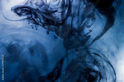 Soft and interesting streaks of paint under water with a dark background. Ideal for use as a background.