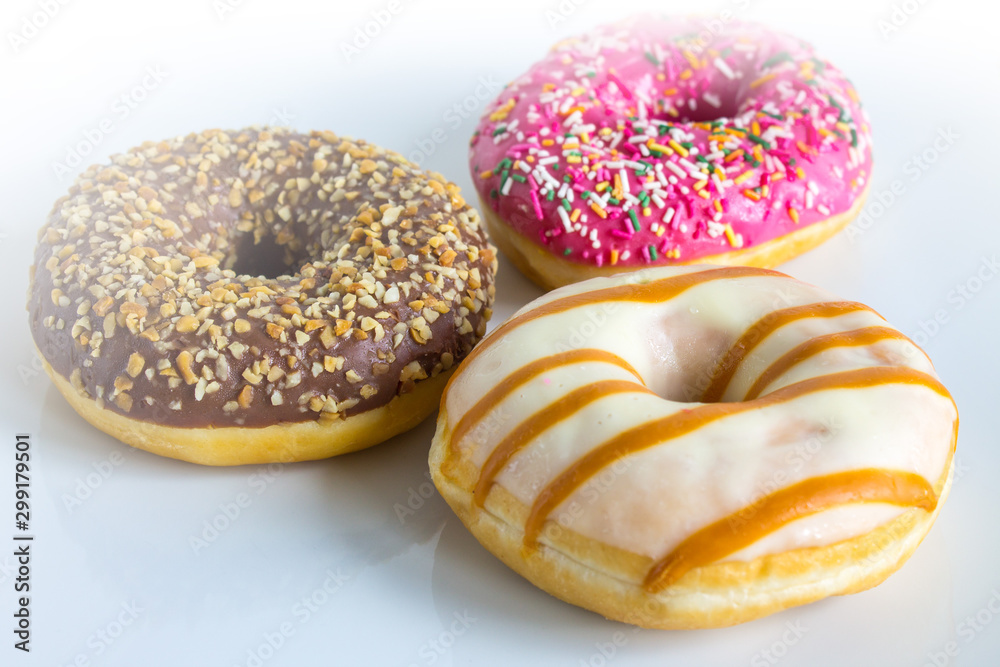 Three doughnuts with colored icing and topping Three doughnuts with colored icing and topping