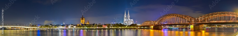 Fototapeta premium Panorama of cologne with the Hohenzollern Bridge over the Rhine River and Cologne Cathedral by night