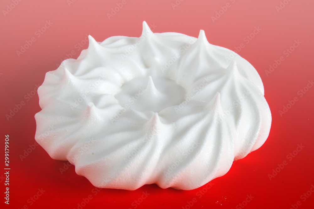 Obraz premium white meringue on red background close up