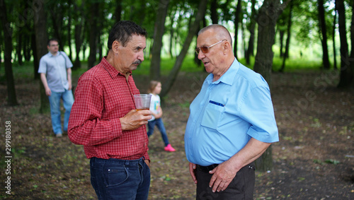 Fototapeta Naklejka Na Ścianę i Meble -  Two elderly people talking in a park.