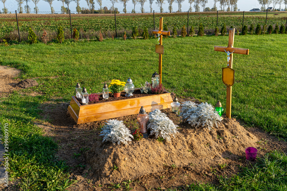 A newly built grave without a tombstone with empty tablets hung on the