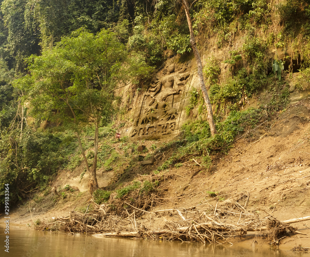 An ancient sculpture of the Hindu goddess Durga carved on the steep  mountain wall on the banks of the Gomti river around the village of  Chabimura in Tripura, India. Stock Photo |