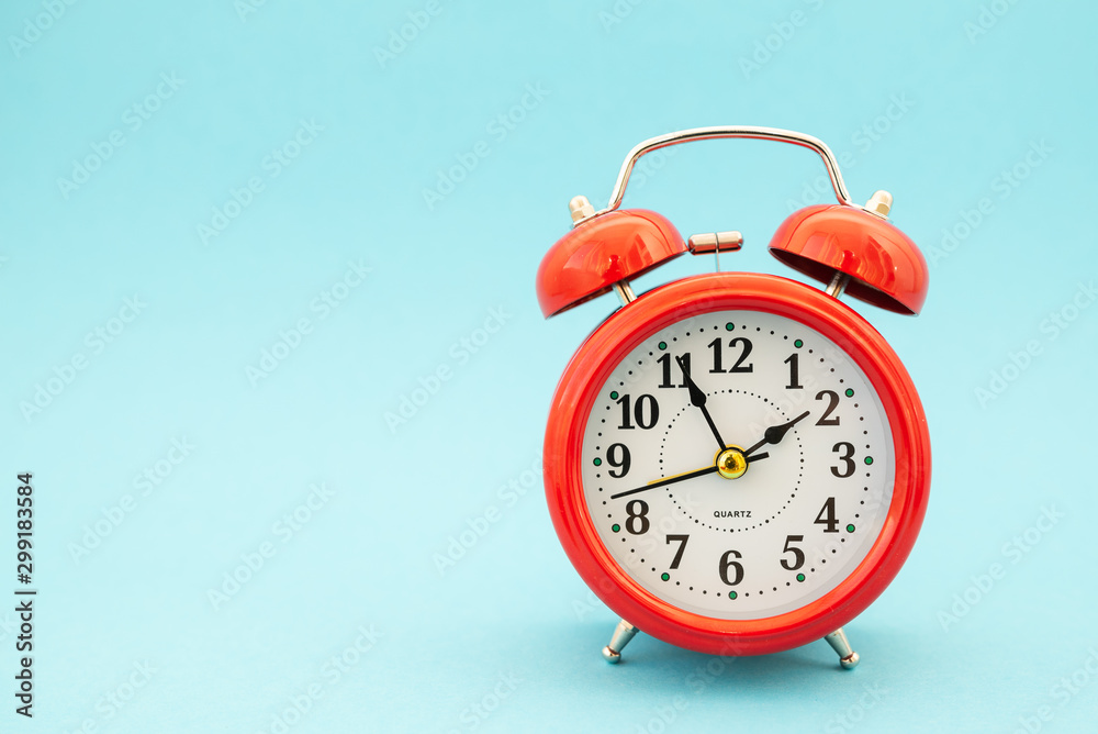 red alarm clock on blue background Stock-bilde | Adobe Stock