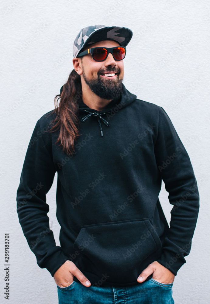 City portrait of handsome hipster man with beard wearing black blank hoodie or hoody with space for your logo or design. Mockup for print City portrait of handsome hipster man with beard wearing black blank hoodie or hoody with space for your logo or design. Mockup for print