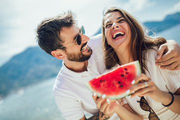 Portrait of happy couple enjoying watermelon on summer holiday