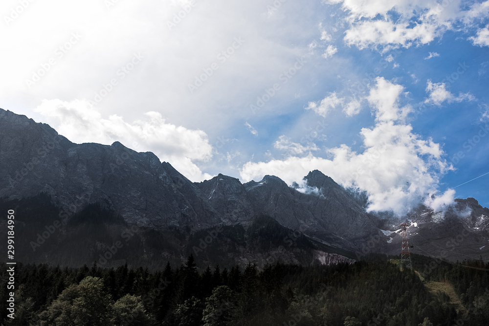 Fototapeta premium Alps mountains, summer panoramic landscape. Blue sky and cable car tower above the forest