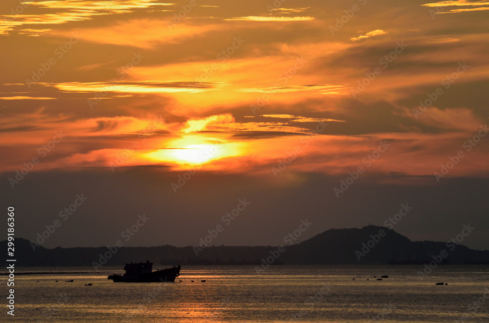 Silhouette of boat mooring at sea with sunset sky background