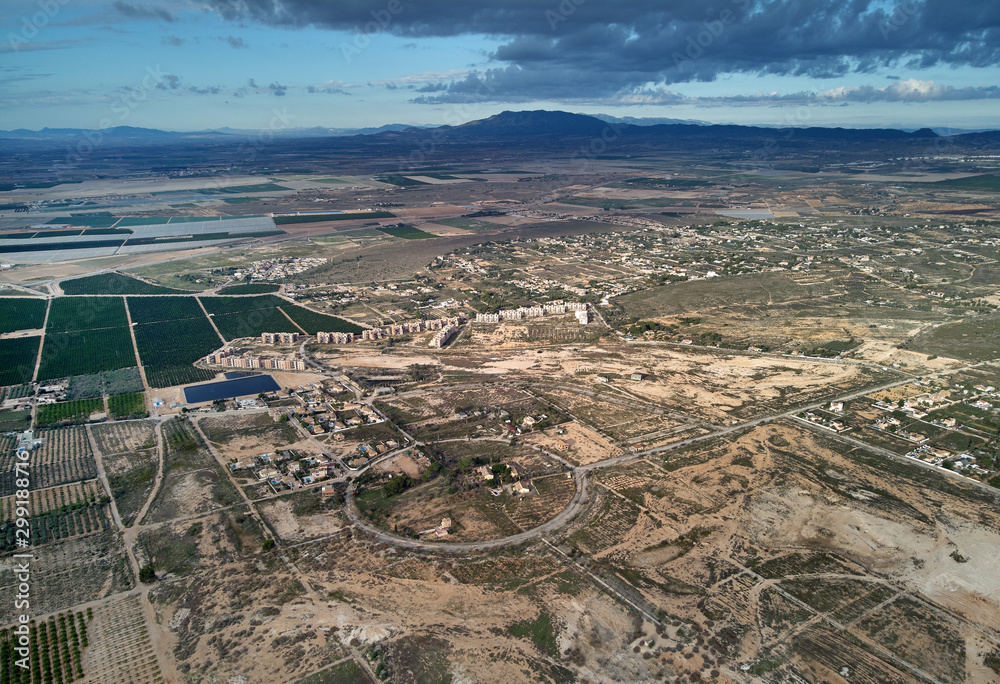 Aerial photography drone point of view region Murcia, countryside area, agricultural fields and meadows, cloudy sky. Spain