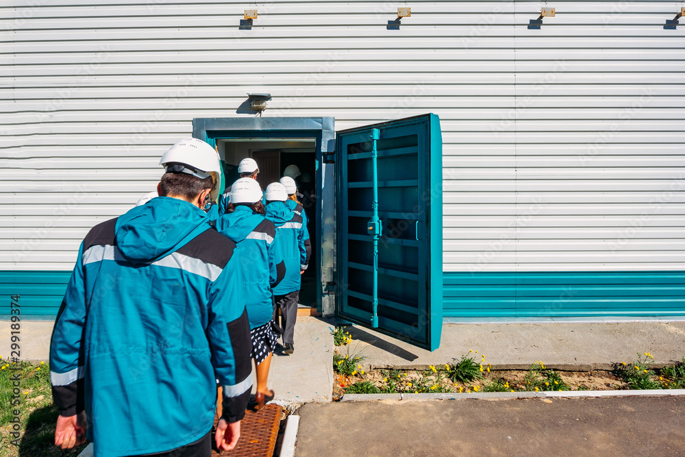 Factory workers entering to armored door of bomb shelter Factory workers entering to armored door of bomb shelter