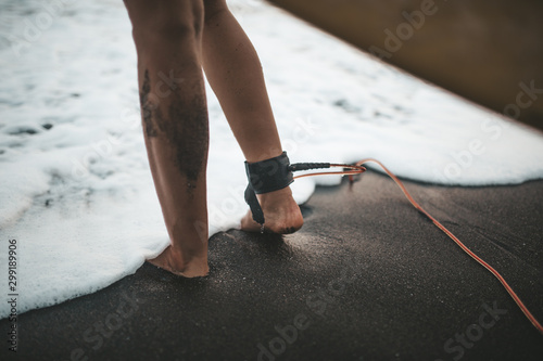 surfer legs with leash