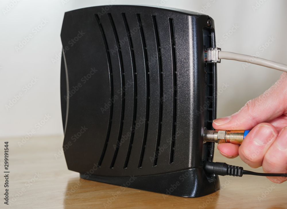 Connecting coaxial cable to cable modem. Man installing high speed