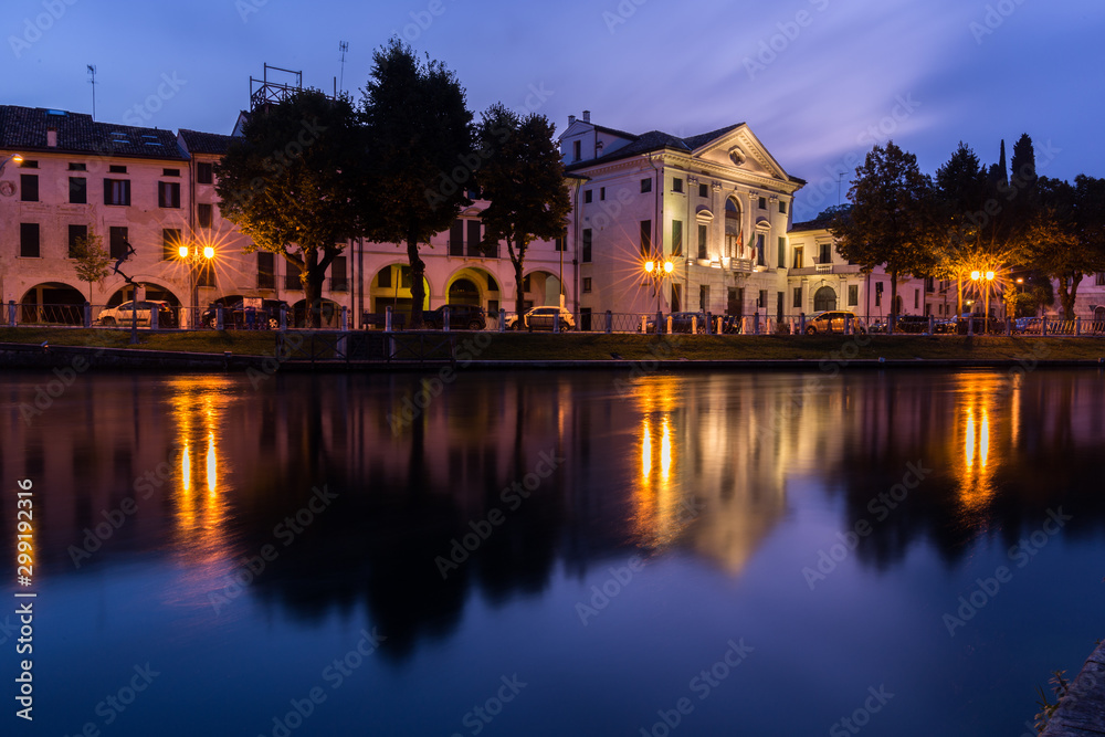 Fototapeta premium Picturesque view on the Sile river in the city center with lights reflections on the water at night Treviso Italy