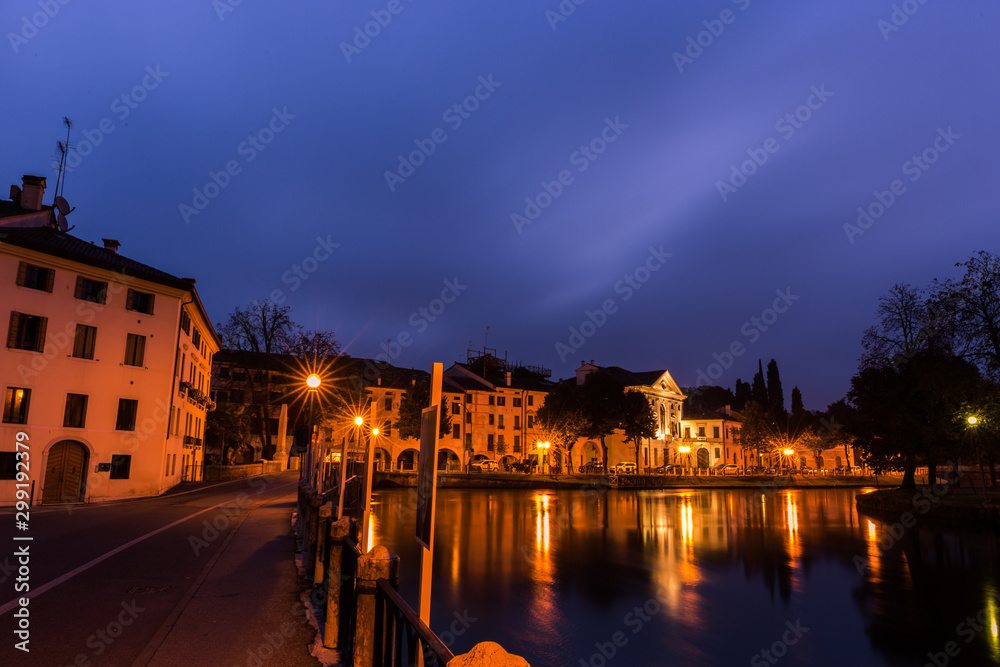 Picturesque view on the Sile river in the city center with lights reflections on the water at night Treviso Italy