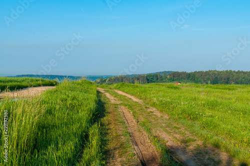 Polna droga szutrowa w otoczeniu zielonej trawy na obszarach wiejskich