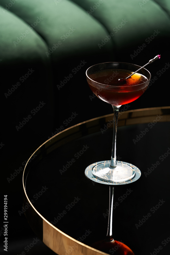 Classic cocktail glass on glass table in night club restaurant, close-up