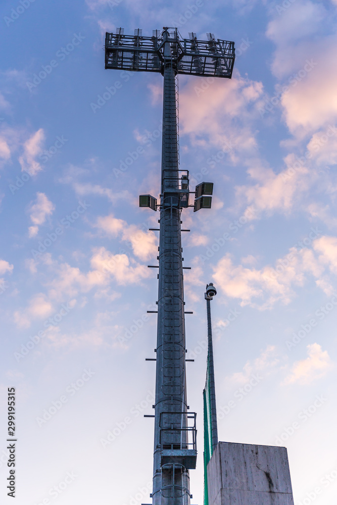 Stadium lights tower with clouds in the background Stadium lights tower with clouds in the background