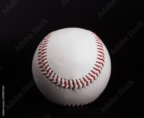 closeup on a white baseball ball with red thread, black background