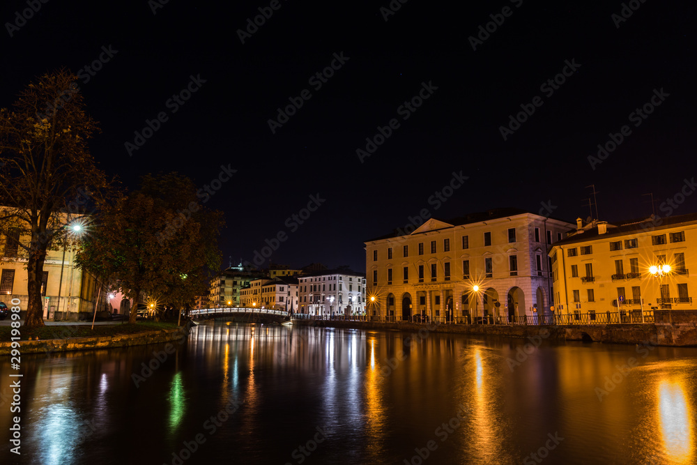 View on the Sile river with university bridge Ponte Dell Universita and The university in the background at night Treviso Italy