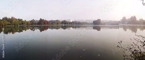 Reflection of trees in the lake during fall season - panorama © dianacoman