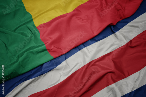waving colorful flag of costa rica and national flag of benin.