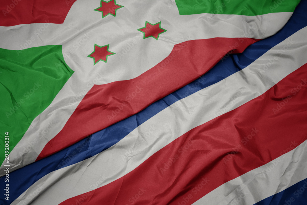waving colorful flag of costa rica and national flag of burundi .