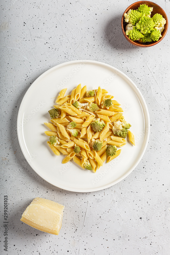 Penne pasta with romanesco cabbage on light gray background Penne pasta with romanesco cabbage on light gray background