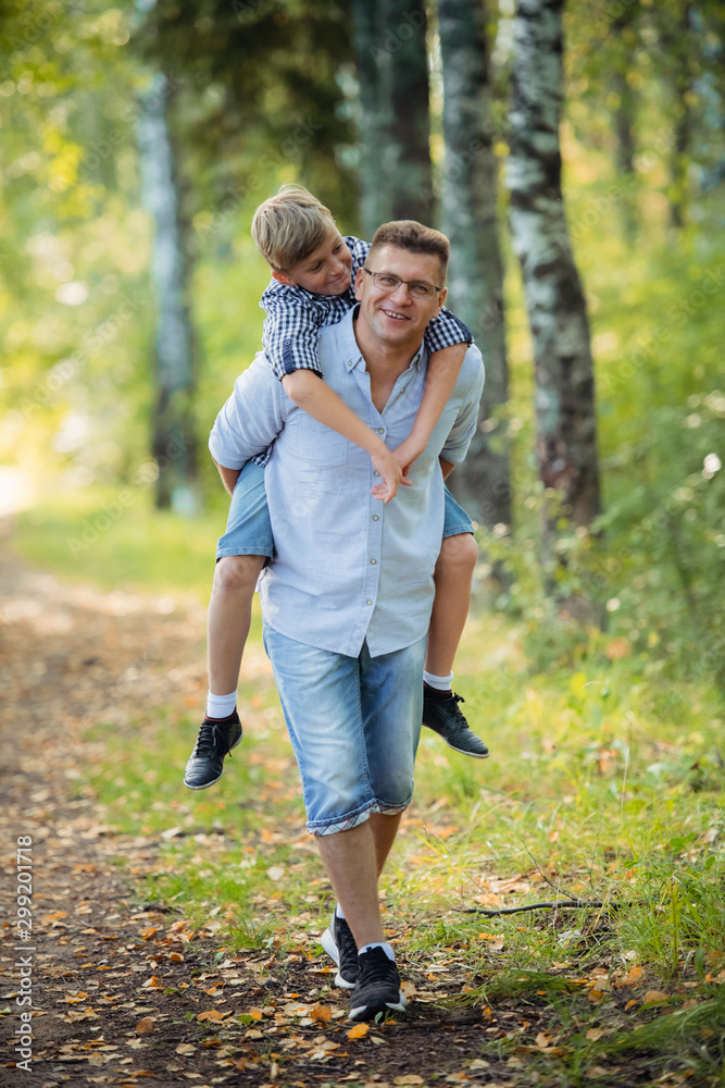 Fototapeta premium Father and son having fun in the park on a sunny day