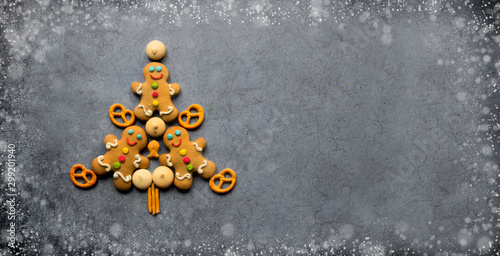Delicious Christmas gingerbread men.Christmas baking ingredients and supplies on dark background.Postcard. Congratulation.Cooking. Christmas minimalism.banner. copy space