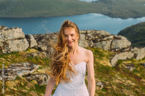 Bride in wedding dress in mountains looking to camera