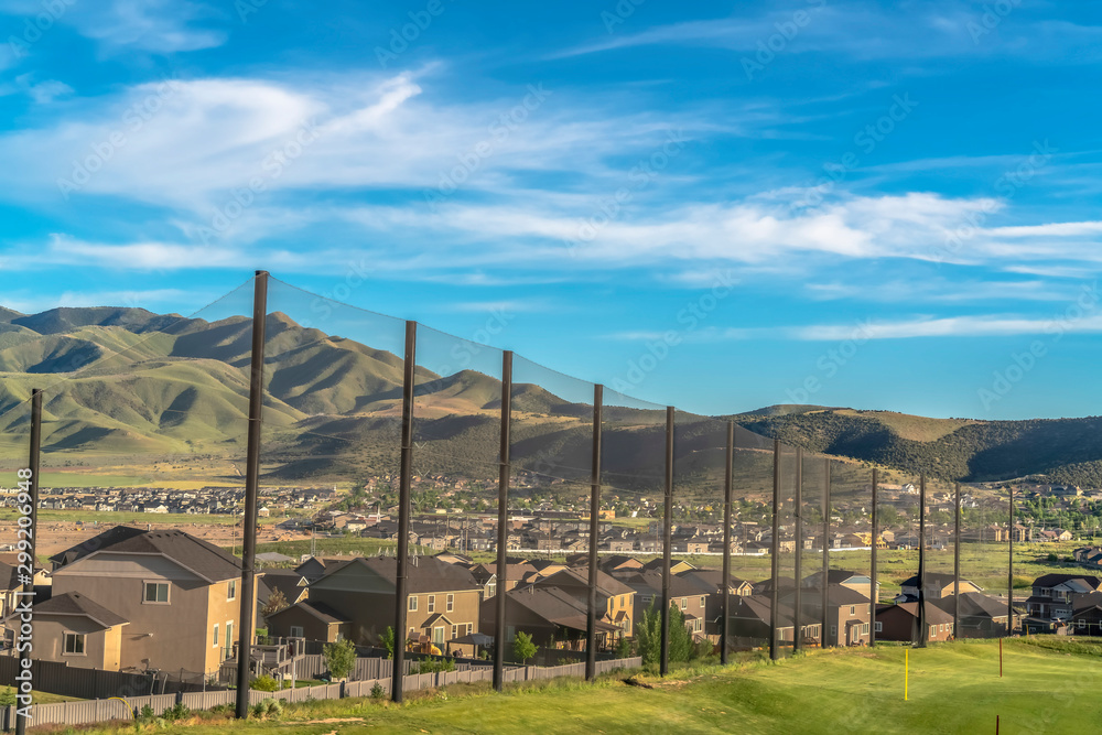 Residential houses and mountain on the other side of the golf course fence Residential houses and mountain on the other side of the golf course fence
