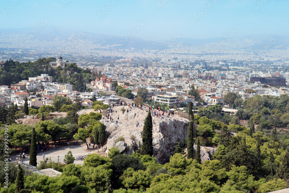 View from Acropolis. St. Marei church to the left.  Tourists taking photos of the Acropolis from a distance. View of the capital in the background.